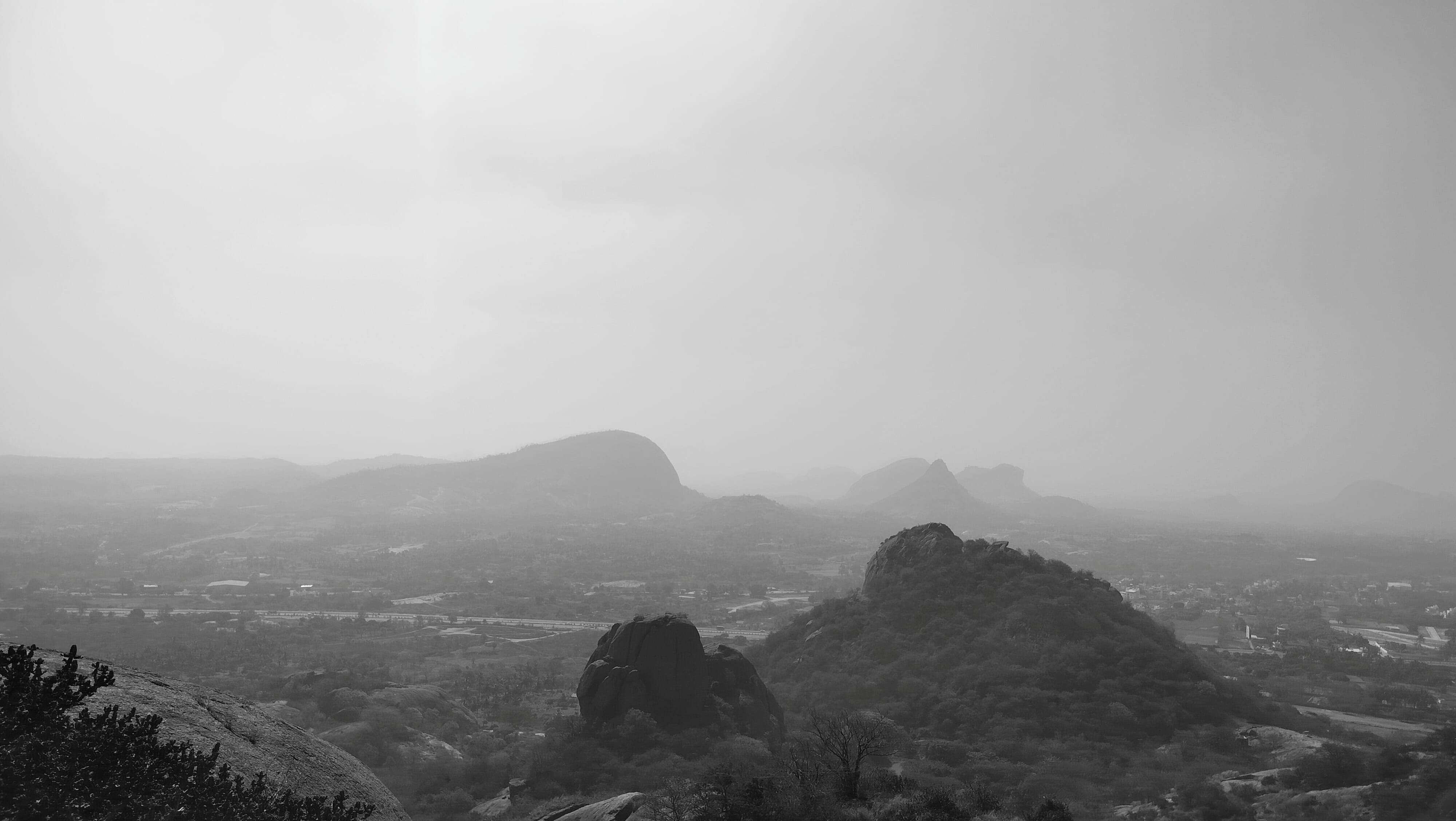 A wide view of misty mountains and a valley under an overcast sky