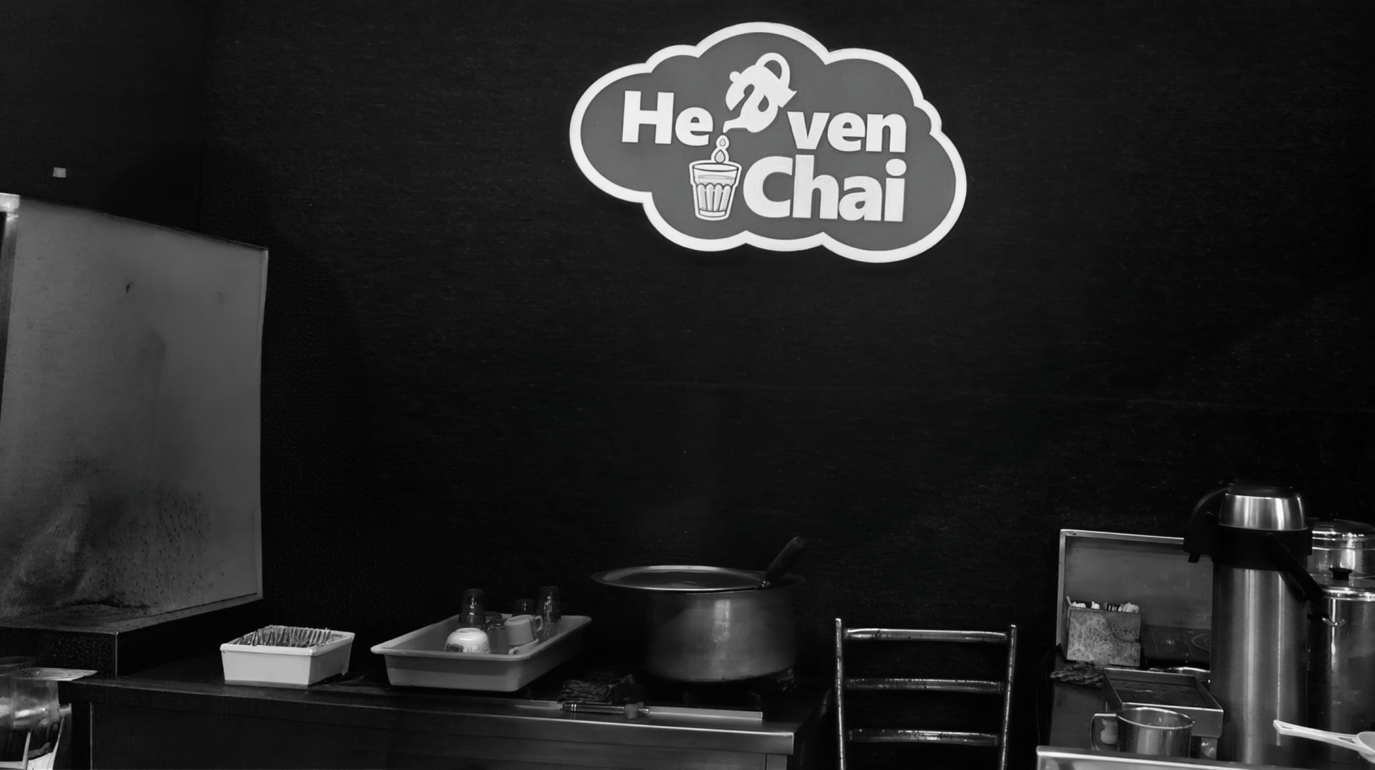 The Heaven Chai logo above a tea preparation counter with pots and glasses