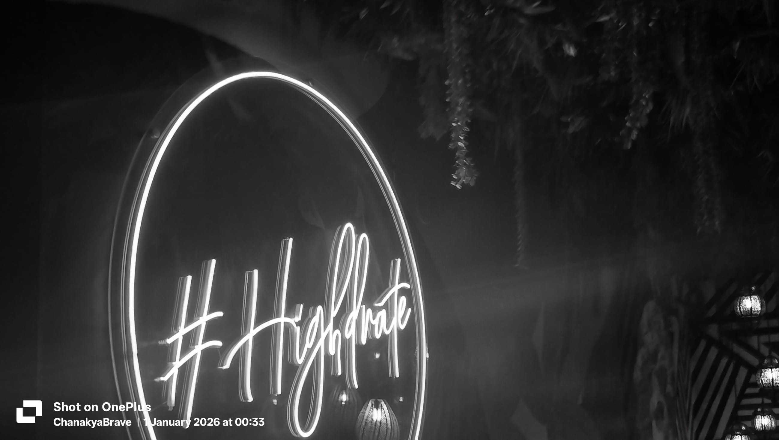 A circular neon sign with the hashtag Highrate in a dim interior