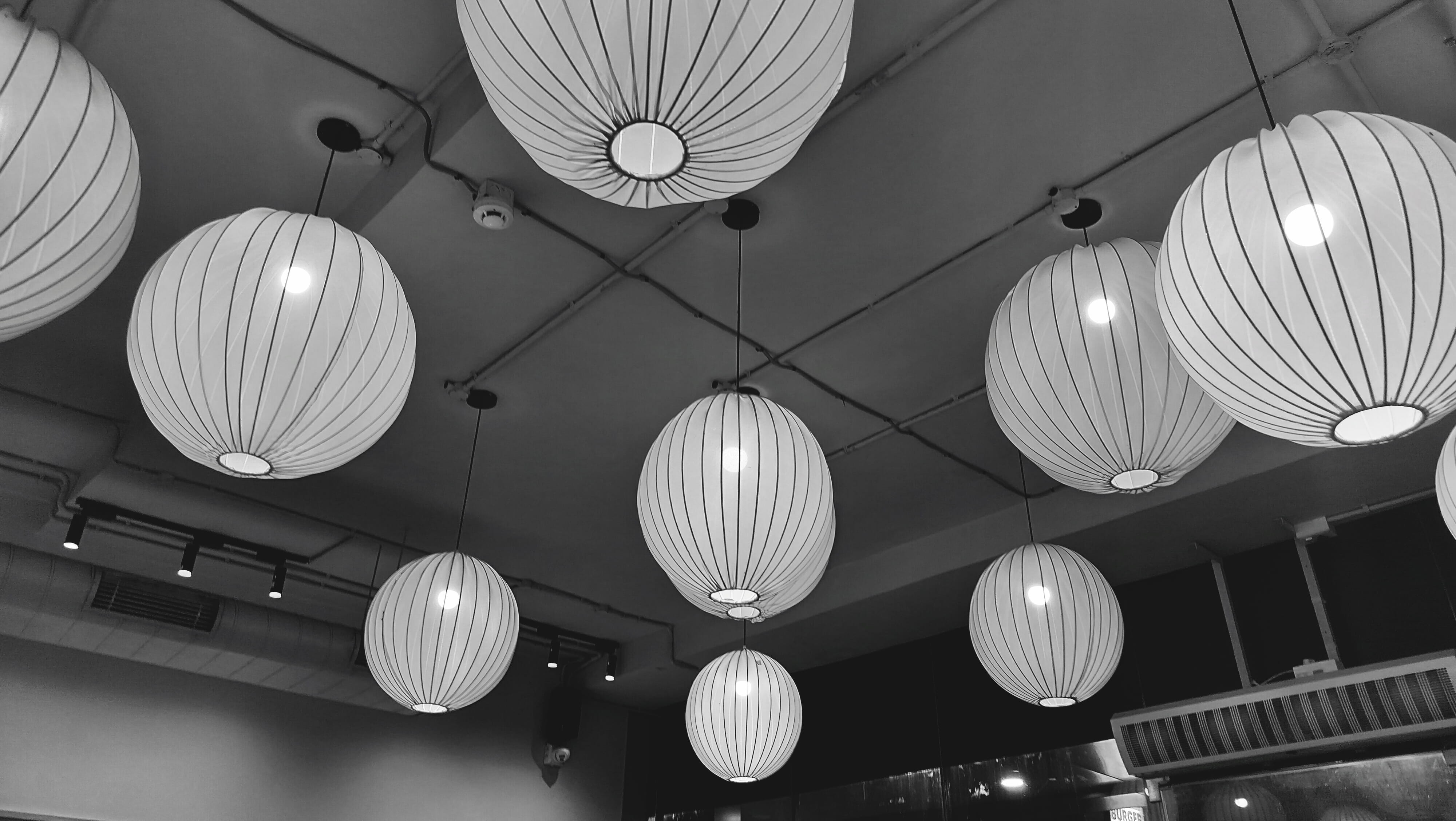 Glowing spherical paper lantern lights hanging from a ceiling