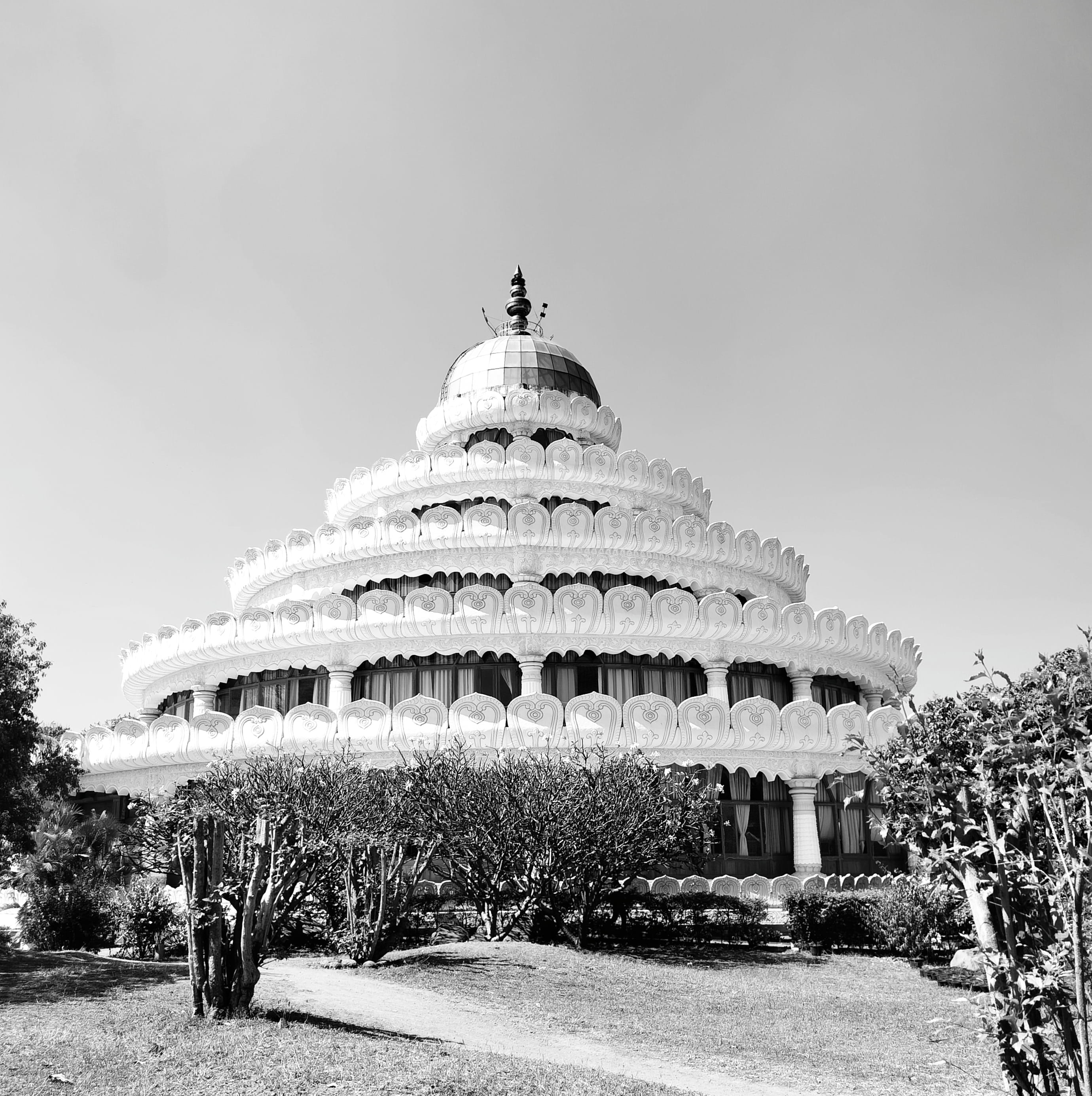 The tiered white Vishalakshi Mantap meditation hall under a clear sky